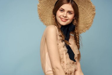 Gri arka planda hasır şapkalı romantik bir kız ve bej renkli bir elbise siyah kurdele duygu modeli.