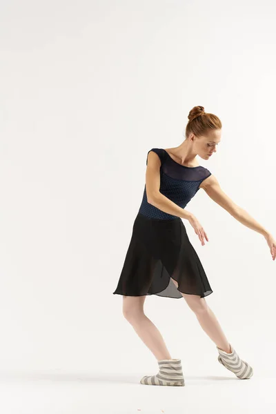Vrouw ballerina in pointe schoenen en in een tutu dansen op een lichte achtergrond in volle groei — Stockfoto