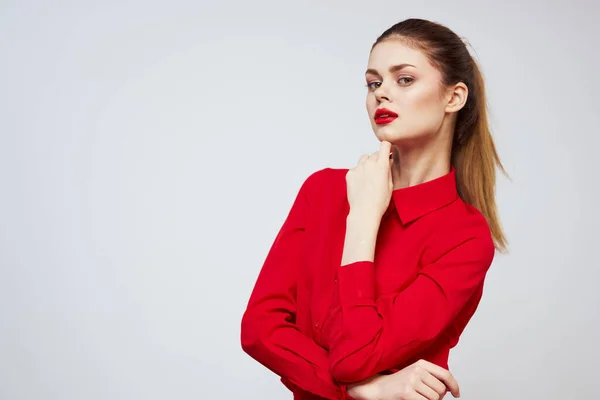 Una hermosa chica con labios rojos y una camisa sobre un fondo claro gestos con sus manos — Foto de Stock