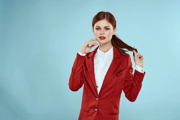 Elegant kvinna i röd jacka ljusa makeup läppar självförtroende beskärd vy blå bakgrund — Stockfoto