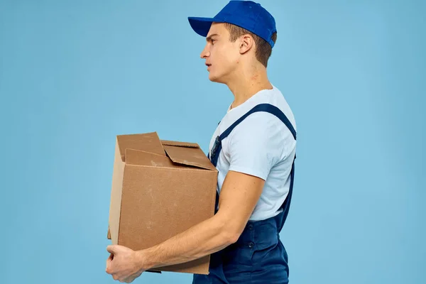 Εργάτης άνθρωπος με χαρτόνι κουτί παράδοσης φορτωτής lifestyle μπλε φόντο — Φωτογραφία Αρχείου