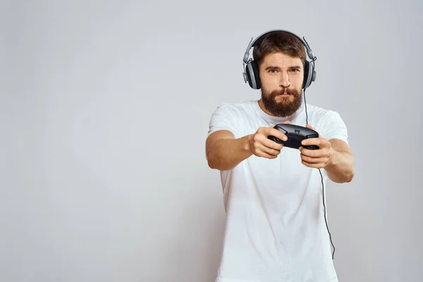 Mann im Kopfhörer mit Gamepad spielt Hobby Unterhaltung Lifestyle Licht Hintergrund — Stockfoto