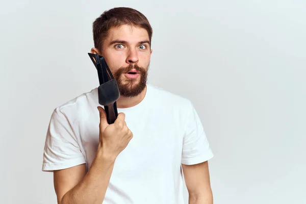 Un hombre con electrodomésticos de cocina en las manos de su camiseta blanca sobre un fondo claro vista recortada — Foto de Stock