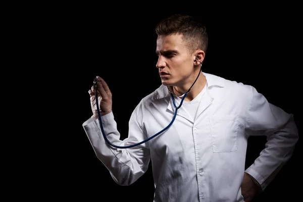 Berufsarzt im Arztkittel mit Stethoskop um den Hals vor dunklem Hintergrund — Stockfoto