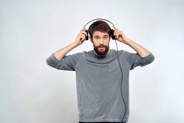 Man in hoofdtelefoon luistert naar muziek levensstijl moderne stijl technologie lichte achtergrond — Stockfoto