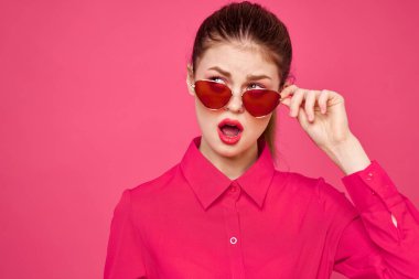 Pembe gömlekli ve kahverengi gözlüklü kadın kırpılmış görünüm modeli duyguları el hareketleriyle resim yapıyor.