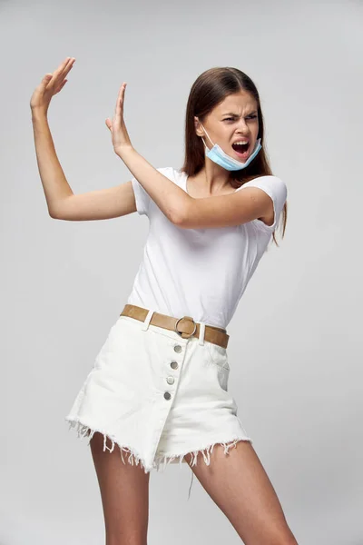 Una donna indignata mostra le mani di lato e si gira su uno sfondo leggero in pantaloncini — Foto Stock