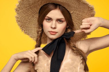 Sarı arka planda kırmızı örgülü kadın portresi.