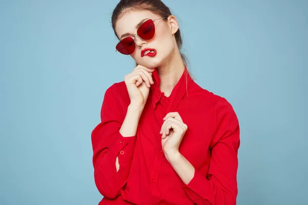 Portrait of a woman with glasses and red lips shirt blue background model — Stock Photo, Image