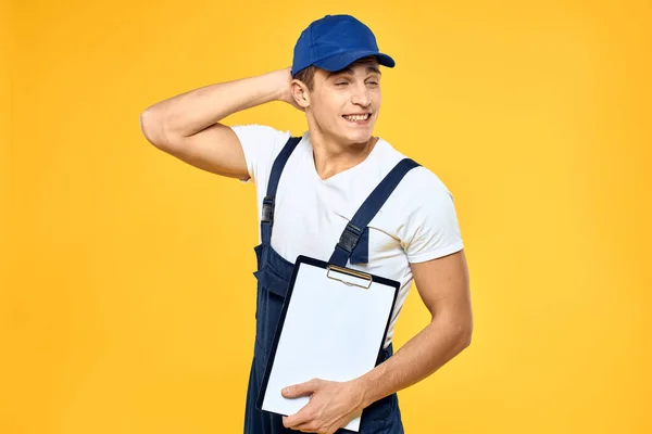 サービス提供サービスのレンダリングの制服文書を作業中の男黄色の背景 — ストック写真
