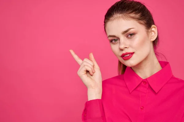 Menina atraente na camisa rosa vista recortada maquiagem brilhante lábios vermelhos gesticulando com as mãos espaço de cópia — Fotografia de Stock