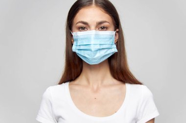 Yüzünde tıbbi maske var. İleriye bak, yakın koruma. 