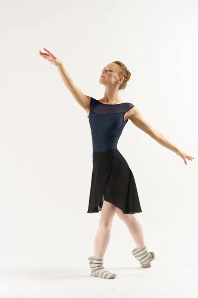 Nő balerina -ban pointe cipő és egy tutu táncok egy könnyű háttér teljes növekedés — Stock Fotó