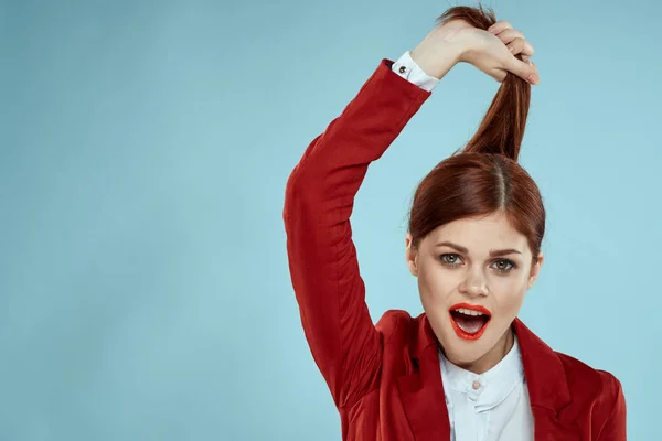 Frau hält Haare mit Händen rote Jacke Kosmetik Nahaufnahme blauer Hintergrund — Stockfoto