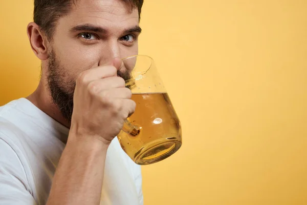 Homme avec une tasse de bière fun alcool style de vie blanc t-shirt jaune fond isolé — Photo