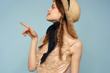 Şapkası ve elbisesi olan kadın duyguları hafif kumaş neşesini büyülüyor.