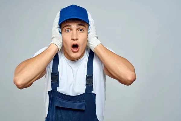 Man worker in forklift uniform delivery service light background