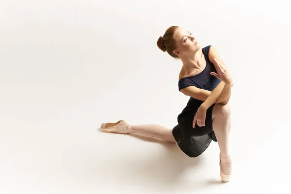 Bailarina en zapatos puntiagudos y en un tutú sobre un fondo claro danza correcta colocación de las piernas figura delgada — Foto de Stock