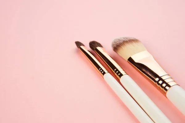 Cepillos de maquillaje sobre un fondo rosa en diferentes tamaños vista recortada —  Fotos de Stock
