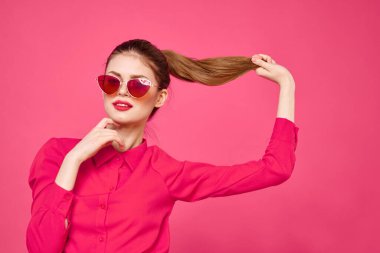 Pembe gömlekli ve kahverengi gözlüklü kadın kırpılmış görünüm modeli duyguları el hareketleriyle resim yapıyor.