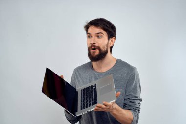 Dizüstü bilgisayarı olan duygusal bir adam. Modern tarz, hafif arka plan.