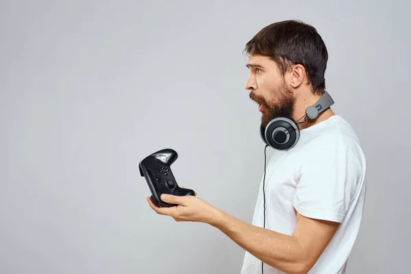 Man met gamepad hoofdtelefoon spelen vrijetijdsbesteding technologie wit t-shirt lichte achtergrond — Stockfoto