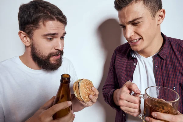 Dwoje przyjaciół pije piwo wypoczynek zabawa alkohol przyjaźń styl życia światło tło — Zdjęcie stockowe