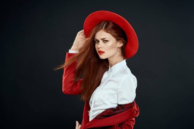 Kırmızı şapkalı zarif kadın ceketi, göz kamaştırıcı yaşam tarzı koyu renk arka plan.