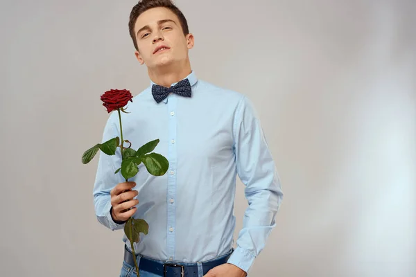 一个长着红玫瑰，穿着浅色衬衫的英俊男子的画像 — 图库照片