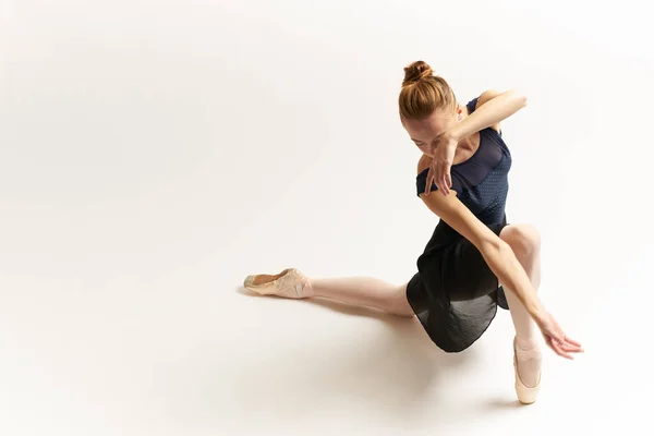 Bailarina em sapatos pontiagudos e em um tutu em uma dança de fundo leve posicionamento correto das pernas figura fina — Fotografia de Stock