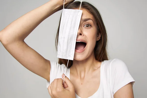 Emocional mujer máscara médica en su cara boca abierta camiseta blanca — Foto de Stock