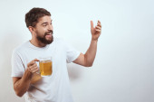 muž s džbánem piva v ruce a bílým tričkem lehké pozadí knír vousy emoce model