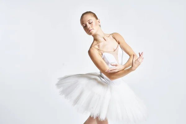 Ballerina in einem weißen Tutu bei der Durchführung von Tanzübungen Flexibilität heller Hintergrund — Stockfoto