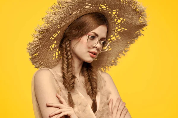 Porträtt av en vacker kvinna med flätor och med en hatt på huvudet på en gul bakgrund beskuren vy — Stockfoto