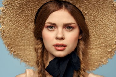 Hasır şapkalı kız portresi yakın çekim at kuyruğu eğlenceli kızıl saçlı mavi arka plan