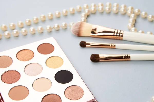 Lidschatten Accessoires Perlen Make-up Pinsel Kollektion professionelle Kosmetik auf grauem Hintergrund — Stockfoto