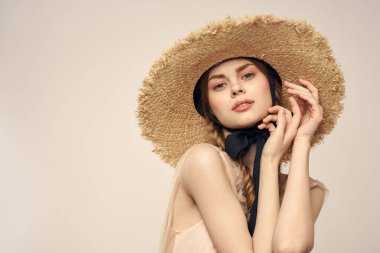 Şapkalı ve arka planda giyinmiş romantik bir kadın elleriyle komik duyguların portresini çiziyor.