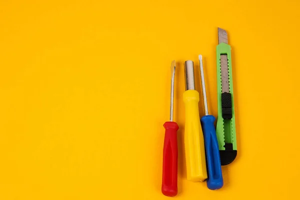 Tournevis couteau papeterie et outils de construction sur fond jaune équipement pour l'industrie de la réparation — Photo