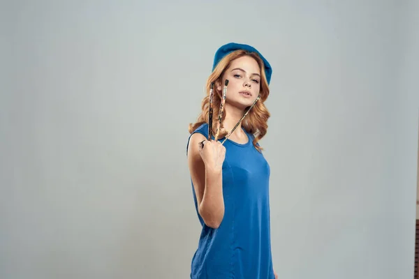 Mulher artista escova na mão azul boina vestido hobby arte estilo de vida luz fundo — Fotografia de Stock