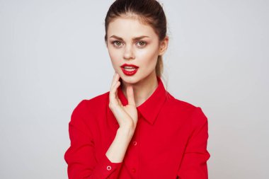 Açık arkaplanda kırmızı dudaklı bir kadının portresi. Makyaj modeli.