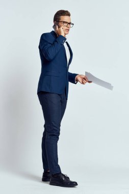 Takım elbiseli bir iş adamı telefonla konuşuyor. Belge teknolojisi yetkilisiyle.