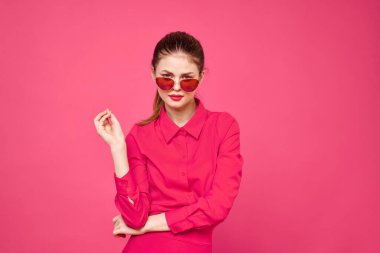 Pembe gömlekli ve kahverengi gözlüklü kadın kırpılmış görünüm modeli duyguları el hareketleriyle resim yapıyor.