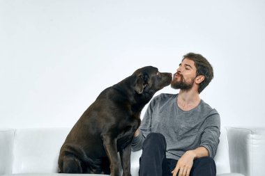 Kanepede evcil köpeği olan bir adam. Arkadaşlarıyla eğleniyor.