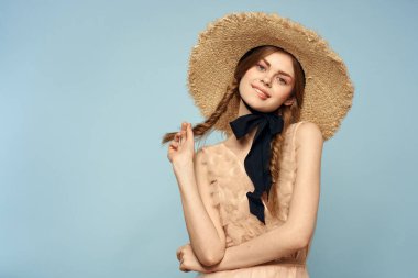 Gri arka planda hasır şapkalı romantik bir kız ve bej renkli bir elbise siyah kurdele duygu modeli.