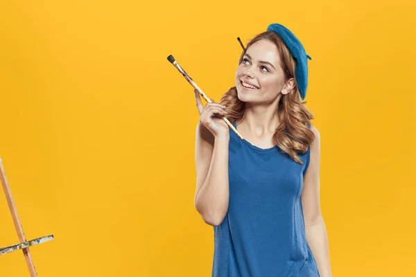 Künstler Frau in blauer Baskenmütze Pinsel Staffelei Kunst Zeichnung Bildung Hobby Kreativer Ansatz gelber Hintergrund — Stockfoto