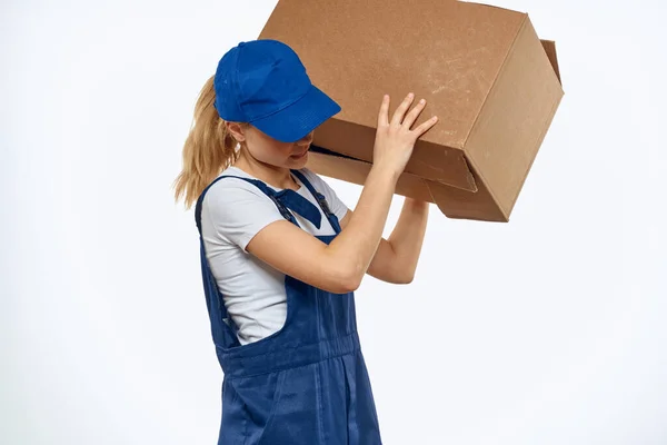 Kvinna arbetar uniform låda i händerna packning service ljus bakgrund — Stockfoto