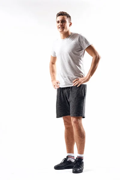 Atletische man op een lichte achtergrond in volle groei en joggen opladen shorts sneakers t-shirt — Stockfoto