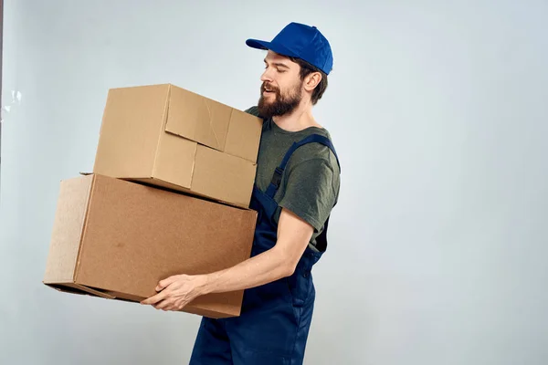 Uomo in uniforme da lavoro con scatole in mano consegna carico stile di vita — Foto Stock