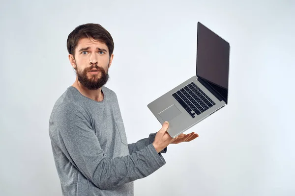 Bearded man with laptop in hands internet communication technology light background