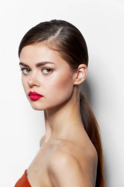Güzel kadın yan duruyor, kırmızı dudaklar çekici görünüyor. 